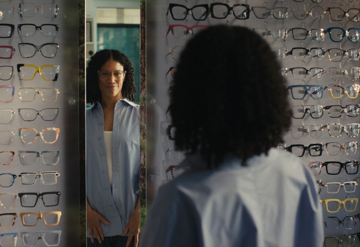 Cliente essayant une monture devant le miroir